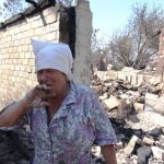 Женщина у её разрушенного обстрелами ВСУ дома