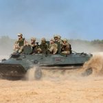 Украинские военнослужащие едут на бронетранспортере на артиллерийском полигоне в селе Девички Киевской области