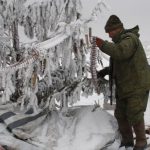 Боец ополчения ДНР вешает патроны на елку на линии разграничения с позициями ВСУ