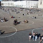 Люди отдыхают в кругах, нарисованных местными властями на площади Святого Петра в Генте