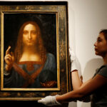 Members of Christie’s staff pose for pictures next to Leonardo da Vinci’s «Salvator Mundi» painting in London