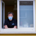 Jonathan Peterschmitt poses at his window during his home quarantine in Bernwiller